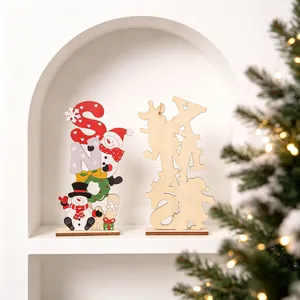 Wooden Christmas snowman and XMAS letter ornaments on white shelf with lights