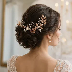 Detailansicht eines Vintage-Brauthaarkamms mit goldenen Blättern und Perlen in einem Dutt.