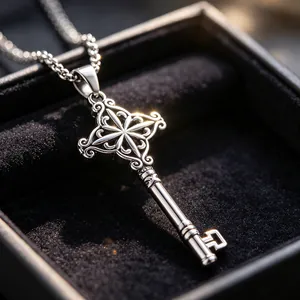 Detailed close-up of an ornate stainless steel key pendant necklace in a velvet jewelry box
