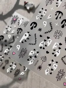 Detailed close-up of Halloween nail stickers featuring ghosts and spider webs motifs