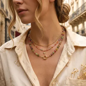 Detail shot of a layered colorful tourmaline beaded necklace with a gold star pendant on model.