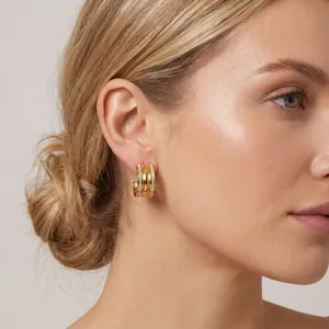 Close-up of elegant gold C-shaped four-row diamond-encrusted earrings on model
