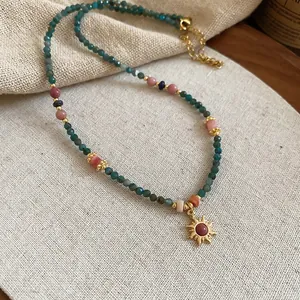 Collier de perles ethnique bohème avec pierres naturelles et un pendentif soleil doré brillant