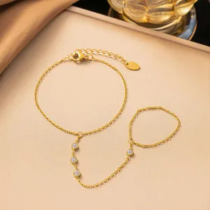 Elegante bracciale schiava in acciaio al titanio dorato con pietre bianche brillanti e anello