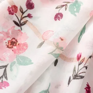 Macro detail of white floral scarf fabric showing subtle silver metallic threads