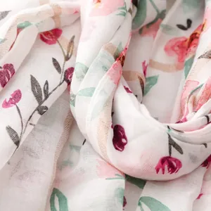 Macro view of a white floral scarf featuring delicate silver thread and cotton-linen texture