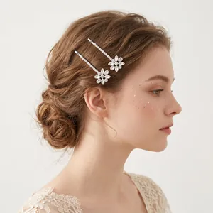 Ensemble de deux épingles à cheveux à fleurs en strass argentés sur un chignon élégant