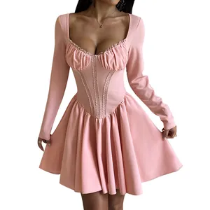 Detailed view of pink long-sleeve dress with lace trim and elegant pleated skirt.