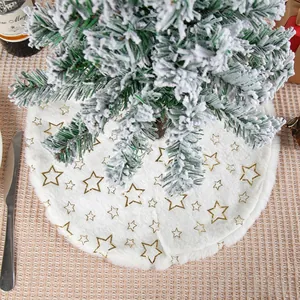 White plush mini Christmas tree skirt with gold star patterns on a snowy tree base.
