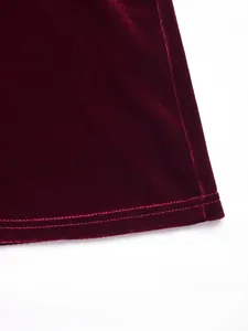 Detail macro view of the double-stitched hem on an elegant burgundy velvet dress