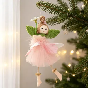 Close-up view of a delicate pink tulle fairy girl ornament hanging on a festive tree branch