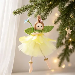 Detail of a handmade angel fairy ornament with a yellow tulle skirt and green wings