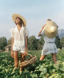 Femmes en tenues de dentelle blanche portant des chapeaux de paille à larges bords
