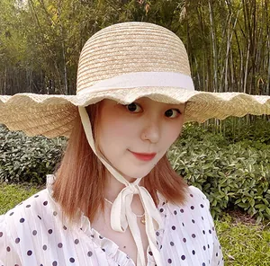 Gros plan d'un chapeau de soleil en paille avec bords festonnés et ruban