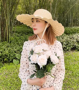 Vue détaillée d'un chapeau de paille à large bord pour femme avec plis coquillages et ruban chic
