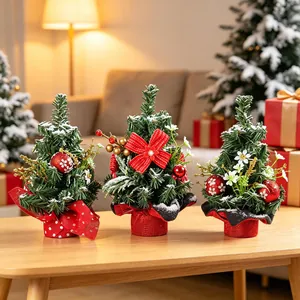 Set of three mini Christmas pine needle trees with red decorations on a wooden table