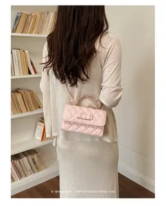 Vista dettagliata di un'elegante borsa rosa trapuntata con fiocco e catena dorata su modella