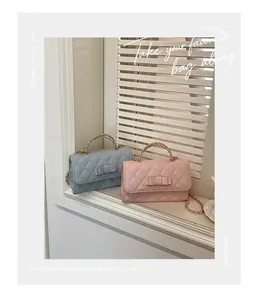 Primo piano di borse con fiocco trapuntate rosa e blu su un davanzale soleggiato ed elegante