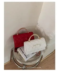 Vista dettagliata di borse trapuntate rosse e bianche con fiocco su uno sgabello metallico