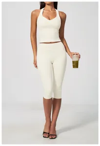 Vue complète d'un ensemble de yoga beige avec débardeur dos nageur et legging capri.