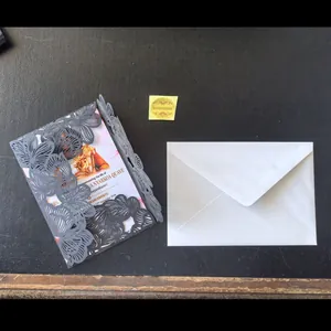 Detail view of a navy laser-cut invitation card with white envelope and gold seal