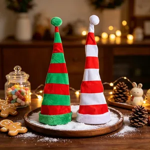 Tall striped velvet Christmas hats in red green and red white stripes displayed on snow