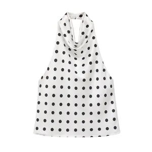Close-up view of a white satin halter top with black polka dots and cowl neck detail