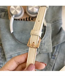 Vue détaillée de la bandoulière réglable blanc cassé avec boucle dorée polie