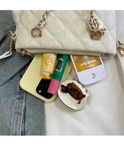 Détail du sac à chaîne matelassé blanc montrant la capacité intérieure avec des objets.