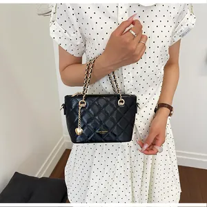 Élégant sac seau matelassé noir avec chaîne dorée et charmant pendentif en cœur