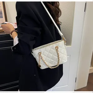 Sac à main élégant blanc matelassé avec chaîne dorée et détail de breloque en cœur