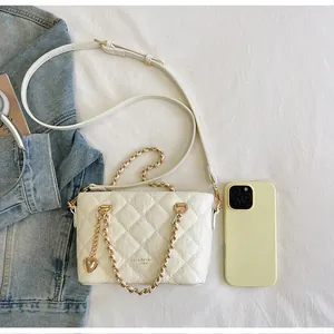 Élégant sac seau matelassé blanc avec chaîne dorée et breloque en forme de cœur