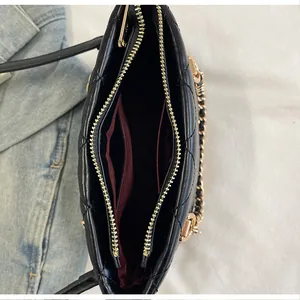 Vue détaillée de l'intérieur d'un sac seau noir matelassé avec doublure bordeaux