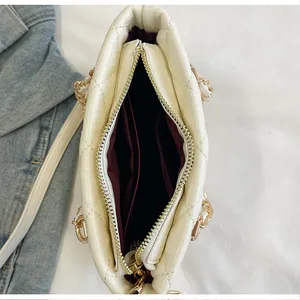 Vue intérieure du sac à main matelassé crème avec doublure rouge et poche zippée