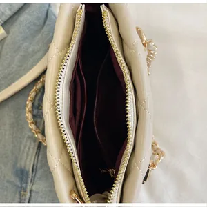 Vue détaillée montrant l'intérieur spacieux et les compartiments du sac matelassé.