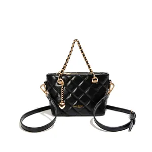 Élégant sac seau matelassé noir avec poignée en chaîne dorée et breloque cœur.