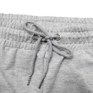 Close-up of elastic waistband with adjustable drawstring and metal aglets on grey sweatpants