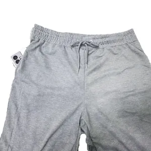 Detail of grey men's joggers featuring elastic waistband and drawstring pocket.