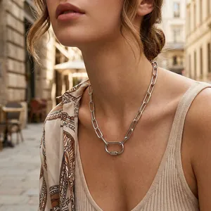 Close-up of silver screw-lock pendant necklace worn by a model in an outdoor setting