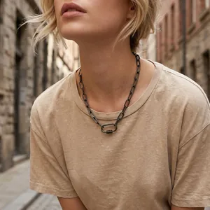 Detail view of a vintage dark grey oval link necklace with screw clasp on a model