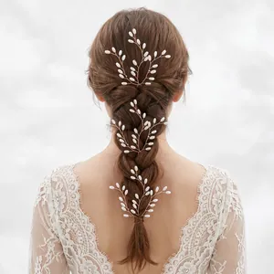 Elegant handmade pearl hair pins set on a bridal braid with intricate lace dress details