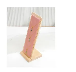 Detailed view of bamboo and pink velvet jewelry display stand for showcasing necklaces.
