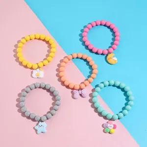 Set of five colorful beaded bracelets with cute cartoon charms for girls and kids