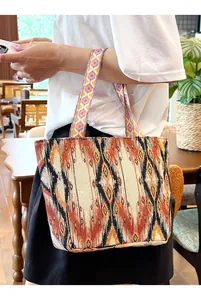 Bolso tote vintage bohemio con patrón étnico mostrado en un entorno interior informal.