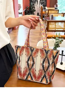 Primer plano de un bolso tote bohemio con patrones étnicos en una mesa de madera