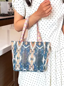 Primer plano de un bolso tote bohemio con patrones étnicos vintage llevado por una mujer