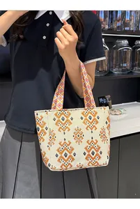 Bolso tote de estilo étnico con bordado geométrico llevado por una persona de forma casual