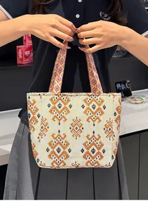 Detalle del bolso tipo tote bohemio con motivos étnicos geométricos y asas duraderas.