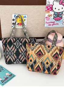 Vista detallada de dos bolsos tote bordados étnicos de estilo boho con patrones geométricos