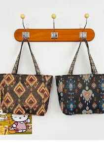 Dos bolsos tote de estilo étnico bohemio con bordados colgados en un perchero
